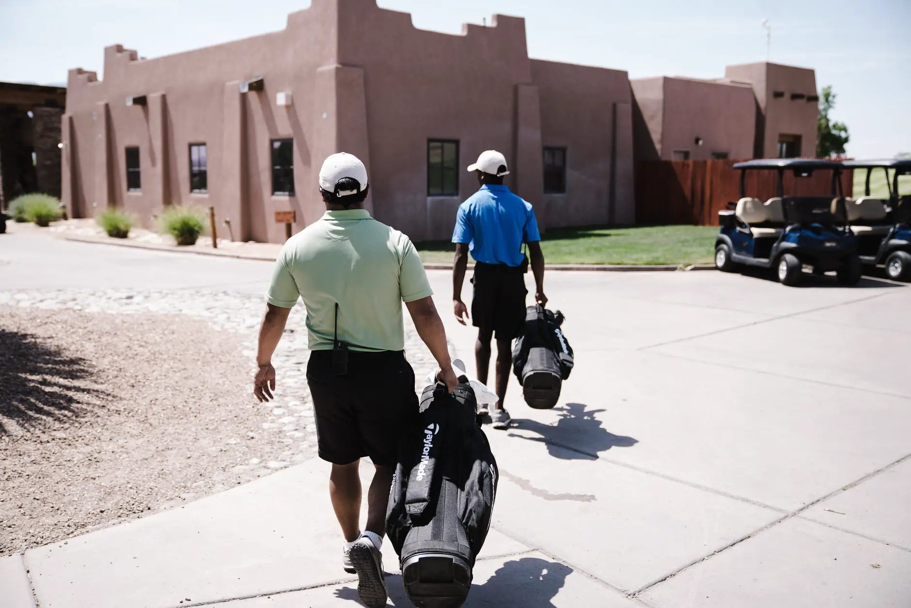 two men holding golf bags