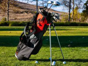 red and black golf bag on grass