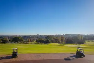 two golf carts on field under blue sky